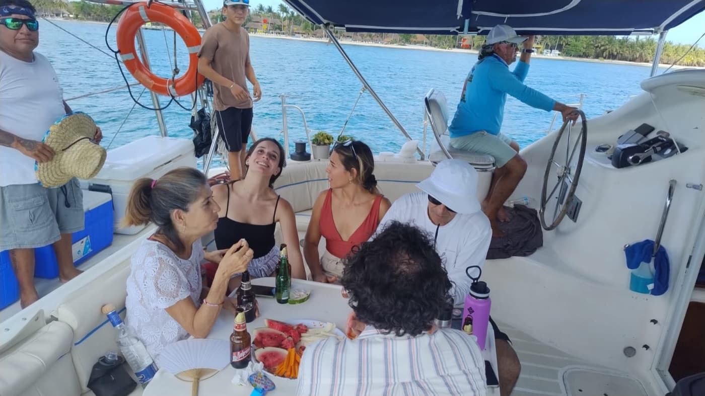 Un grupo de huéspedes comparte sandía y bebidas en la bañera mientras el capitán lleva el timón