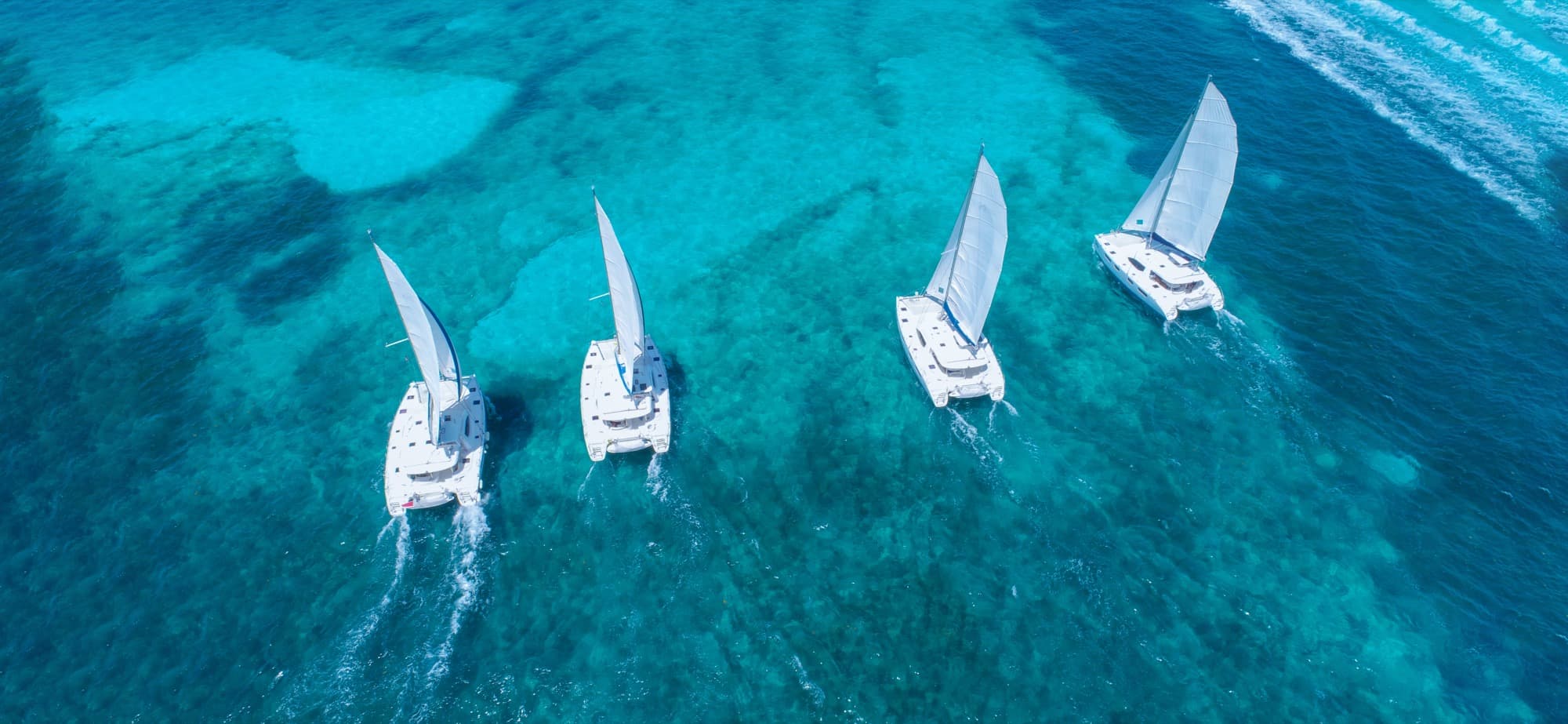 Cancun tours aerial view of catamarans in turquoise Caribbean waters